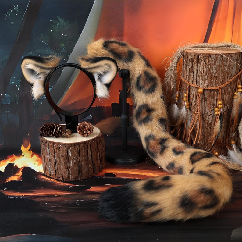 Puede incluir: Un conjunto de orejas de animal de piel sint&eacute;tica en una diadema negra y una cola larga a juego de piel sint&eacute;tica. Las orejas y la cola presentan un patr&oacute;n de leopardo en tonos beige y marr&oacute;n con manchas negras y una punta negra s&oacute;lida.