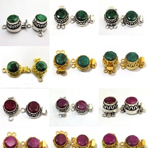May include: A set of 10 silver and gold tone clasps with green and red gemstone accents. Each clasp features a round gemstone surrounded by a decorative metal frame. The clasps are designed to be used as jewelry closures.