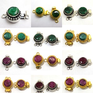 May include: Two sets of silver and gold tone clasps with green and red gemstone accents. Each clasp has a round gemstone surrounded by a beaded border. The clasps are designed to be used as jewelry connectors.