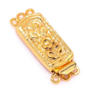 May include: Gold-toned metal clasp with a floral design and three loops for attaching to a necklace or bracelet.