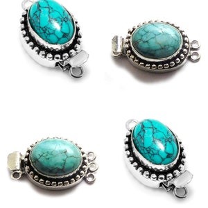 May include: Four silver-toned oval-shaped clasps with turquoise stones. Each clasp has a beaded border and a decorative design.