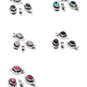 May include: A collection of silver-toned jewelry clasps, each featuring a different colored gemstone. The gemstones include purple, blue, pink, black, and red. The clasps are oval-shaped with a small loop on each end for attachment.