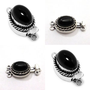 May include: Black onyx gemstone toggle clasp with silver tone metal setting. The clasp has a rope design around the edge of the setting and three loops for attaching to a necklace or bracelet.