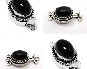 Op de afbeelding: Zwarte onyx edelsteen toggle sluiting met zilverkleurige metalen setting. De sluiting heeft een touwontwerp rond de rand van de setting en drie lussen om aan een ketting of armband te bevestigen.