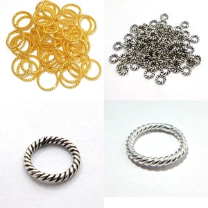 Peut inclure: Un tas de joncs torsadés en or et en argent. Les joncs mesurent environ 1,25 cm de diamètre. Il y a deux gros plans d'un seul jonc.