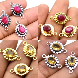 May include: Oval gemstone connectors in silver and gold settings. The gemstones are red and yellow. These connectors are suitable for jewellery making and crafting. The metal finishes vary.