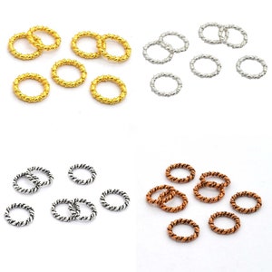 May include: Assortment of twisted metal jump rings in gold, silver, and copper. The rings are approximately 10mm in diameter.