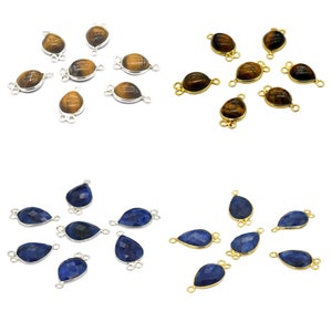 May include: Assortment of gemstone connector charms with silver and gold accents. The charms feature teardrop-shaped tiger's eye and blue sapphire stones.
