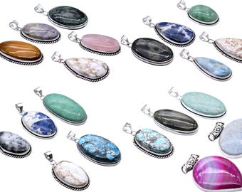 May include: A collection of gemstone pendants in various shapes and colors, including oval, teardrop, and round. Each pendant has a silver-colored metal border and a loop for a chain. The gemstones range from blue to green, pink, and brown.