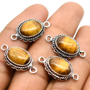 May include: Four silver oval-shaped connector charms with tiger's eye gemstone cabochons. Each charm has two loops for attaching to jewelry.