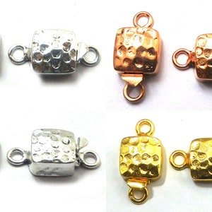 May include: Four pairs of square-shaped metal clasps with a hammered texture. The clasps are available in silver, rose gold, and gold.