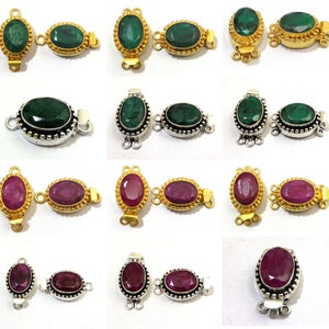 Puede incluir: Un juego de 12 cierres ovalados de piedras preciosas para la elaboración de joyas. Los cierres están hechos de metal plateado y dorado y presentan piedras preciosas de esmeralda verde y rubí rojo.