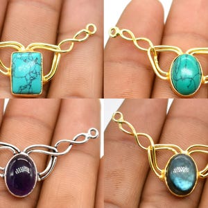 May include: Four gemstone pendant connectors. The connectors feature a gold or silver-coloured metal design with a central gemstone. Gemstones include turquoise, green, purple, and blue-green. Each connector has loops on each end.