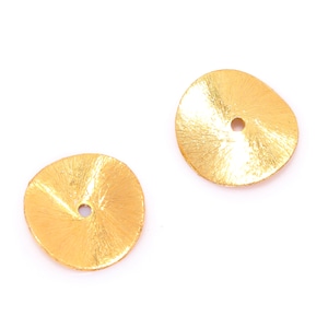May include: Two gold-coloured metal discs with a small hole in the centre. The discs have a textured surface.