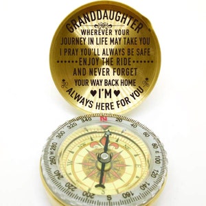 May include: A gold compass with a black inscription that reads "Granddaughter Wherever your journey in life may take you I pray you'll always be safe ... Enjoy the ride ... And never forget your way back home I'm always here for you".