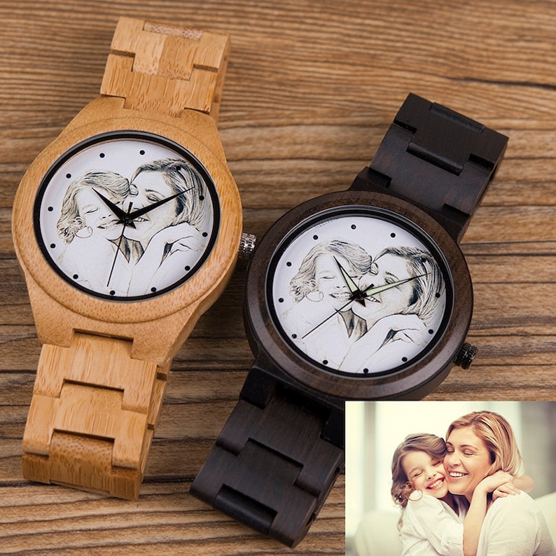 May include: Two wooden wristwatches with black and brown bands. The watch faces feature a black and white photo of a mother and daughter.