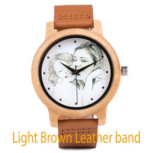 May include: A wooden wristwatch with a light brown leather band. The watch face features a black and white photo of a mother and child.