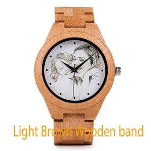 May include: A light brown wooden wristwatch with a white face and a photo of a mother and child. The watch has a black band.