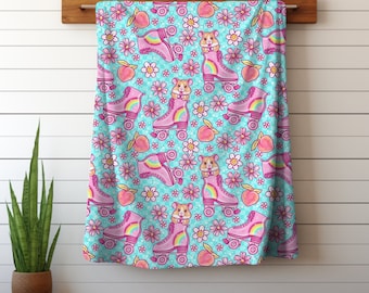 May include: A blue and pink patterned fabric with a repeating design of hamsters on roller skates, peaches, and flowers.