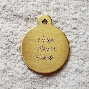 May include: A large, round, brass circle tag with the words "Large Brass Circle" engraved on it.
