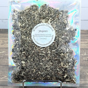 May include: A clear plastic bag filled with dried mugwort herb. The bag has a label that reads "Witchmade Studios Mugwort Protection, Cleansing, Lost Fertility. Not for internal use during pregnancy. www.witchmadestudios.com"