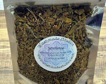 May include: A silver resealable pouch containing dried mistletoe herb. The pouch has a white label with the text "Witchmade Studios" and "Mistletoe" in black lettering. The label also includes the text "Protection, Love, Luck, Fertility, Sleep, Dreams, Banishing" in smaller black lettering. The label has a website address: "www.witchmadestudios.com".