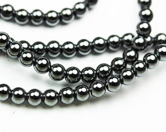 May include: A strand of black hematite beads. The beads are round and have a shiny, metallic finish.