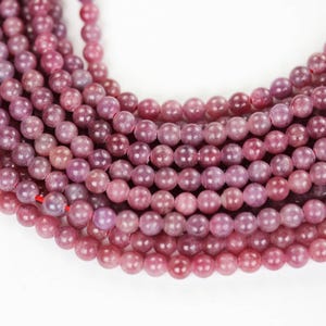 Peut inclure: Un brin de perles rondes en lépidolite rose. Les perles sont lisses et légèrement translucides.