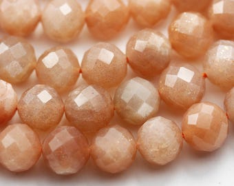May include: A strand of faceted sunstone beads in a peachy orange color. The beads are round and have a smooth, polished finish.