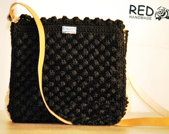 Handmade knitted handbag with genuine leather round her drawn newspaper and leather handle straight.