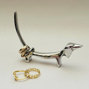 Adorable and must-have Dachshund Dog Ring Holder crafted in a smooth silver finish.