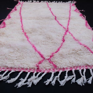 May include: White shag rug with a pink geometric pattern and white fringe.