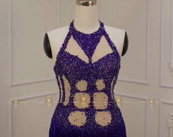May include: A purple and blue beaded halter-style dance costume with a sheer bodice and a fringe bottom.