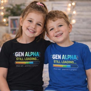 May include: Two children wearing black and blue t-shirts with the text "GEN ALPHA STILL LOADING..." and a loading bar graphic. The shirts also read "please wait... greatness in progress."
