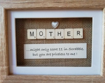 Könnte beinhalten: Gerahmtes Kunstwerk mit dem Wort „MOTHER“ aus Scrabble-Steinen. Ein kleines weißes Herz befindet sich darüber. Darunter steht auf einer Karte: „...might only score 11 in Scrabble, but you are priceless to me!“.