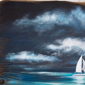May include: A painting of a sailboat on a dark blue sea with white clouds in the sky.