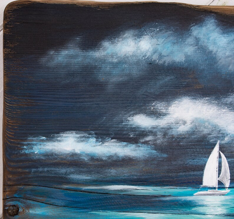 May include: A painting of a sailboat on a dark blue sea with white clouds in the sky.