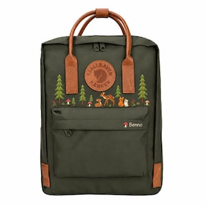May include: An olive green backpack with brown leather handles and trim. The front features a circular Fjällräven Kånken logo, a forest scene with pine trees, mushrooms, a deer, and a fox, and the text Benno next to a small mushroom icon.