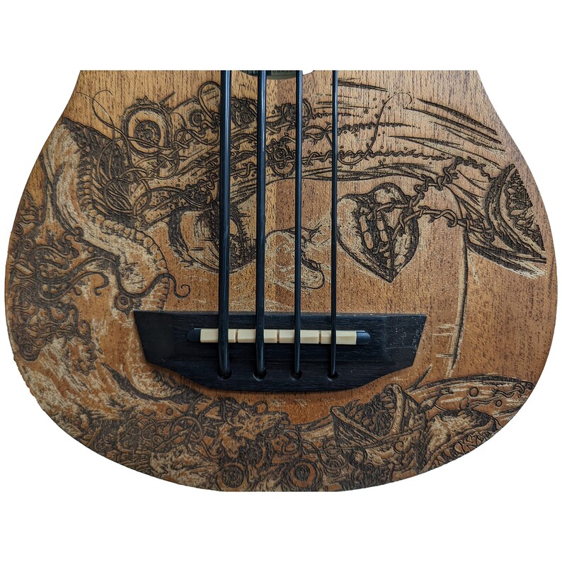 Może przedstawiać: Basowy gitar elektryczny wykonany z drewna z wypalonym na nim szczeg&oacute;łowym, skomplikowanym wzorem. Wz&oacute;r przedstawia serce, rybę i inne abstrakcyjne kształty.