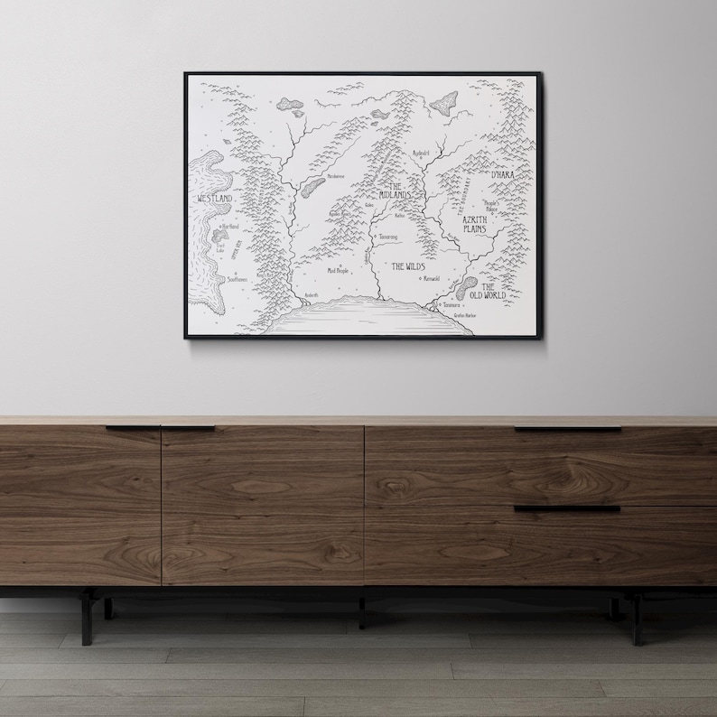 K&ouml;nnte beinhalten: Ein Schwarzwei&szlig;-Kartendruck einer fiktiven Welt mit dem Titel "The Old World" und den Namen verschiedener Regionen, darunter "The Wilds" und "The Aetrith Plains". Die Karte ist in einem schwarzen Rahmen gerahmt und h&auml;ngt an einer wei&szlig;en Wand &uuml;ber einem Holzkasten.