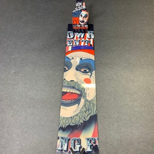 Puede incluir: Un marcap&aacute;ginas con una ilustraci&oacute;n colorida de un payaso con el texto "Own Your En't" y "King Fu" en la parte inferior.
