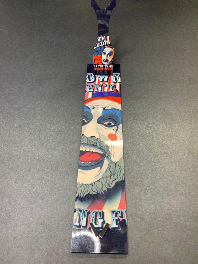 Puede incluir: Un marcap&aacute;ginas con una ilustraci&oacute;n colorida de un payaso con el texto "Own Your En't" y "King Fu" en la parte inferior.