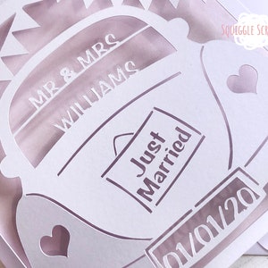 K&ouml;nnte beinhalten: Wei&szlig;er Papierschnitt eines Autos mit den Worten "Mr. & Mrs. Williams" und "Just Married" darauf. Das Auto hat einen Herz-Ausschnitt an der Seite und ein Nummernschild mit der Aufschrift "01/01/20".