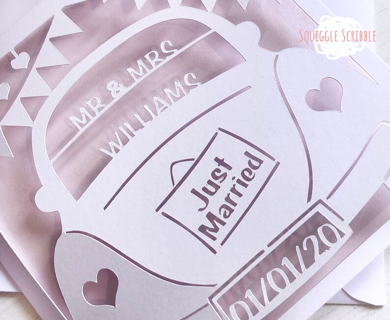 K&ouml;nnte beinhalten: Wei&szlig;er Papierschnitt eines Autos mit den Worten "Mr. & Mrs. Williams" und "Just Married" darauf. Das Auto hat einen Herz-Ausschnitt an der Seite und ein Nummernschild mit der Aufschrift "01/01/20".