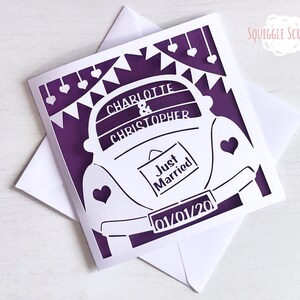 K&ouml;nnte beinhalten: Eine aus Papier ausgeschnittene Karte in Lila und Wei&szlig; mit einem wei&szlig;en Auto, einem Schild mit der Aufschrift "Just Married" und dem Text "Charlotte & Christopher 01/01/20".