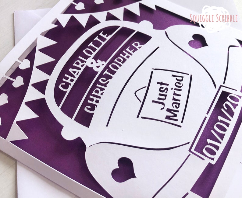 K&ouml;nnte beinhalten: Eine wei&szlig;e, ausgeschnittene Karte mit einem violetten Hintergrund. Die Karte zeigt ein Auto mit den Worten "Charlotte & Christopher" und "Just Married". Das Datum "01/01/20" ist ebenfalls auf der Karte.