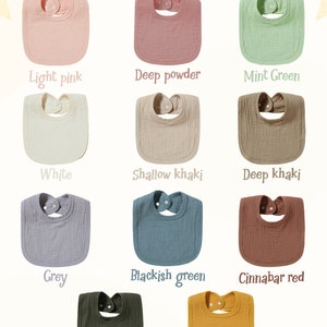 May include: Color selection chart for baby bibs. The bibs are made of a soft, textured fabric and come in a variety of colors, including light pink, deep powder, mint green, white, shallow khaki, deep khaki, grey, blackish green, cinnabar red, green, and orange.