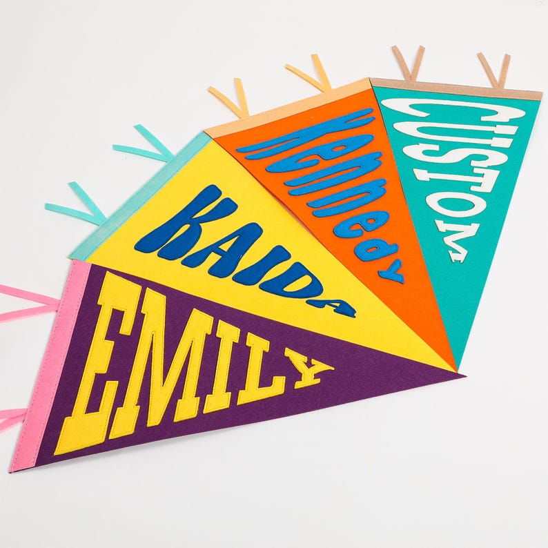 K&ouml;nnte beinhalten: Ein farbenfroher Filz-Wimpelbanner mit den Namen "Emily", "Kaida", "Kennedy" und "Custom" in einer fetten, verspielten Schrift.