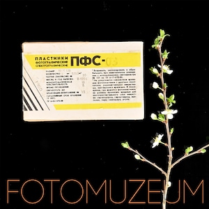 May include: A vintage box of photographic plates, with Cyrillic text, and the label "ПФС-03". The box is yellow and white, with black text. A sprig of a flowering tree is on the right side of the image. The word "FOTOMUZEUM" is at the bottom.