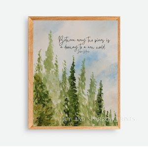 May include: A watercolor painting of a forest with a quote by John Muir: "Between every two pines is a doorway to a new world." The painting is framed in a light brown wood frame.